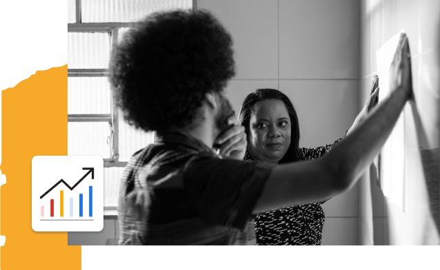 black and white photo of two people talking and placing their hands on a wall